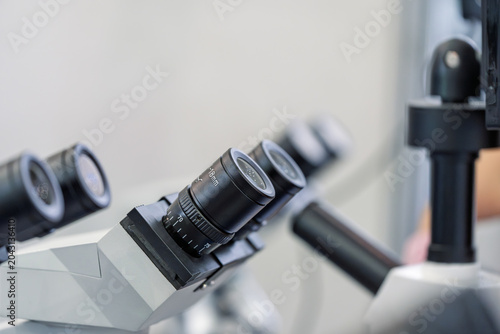 Fotografie Close up shot of multi eyepiece microscope in laboratory