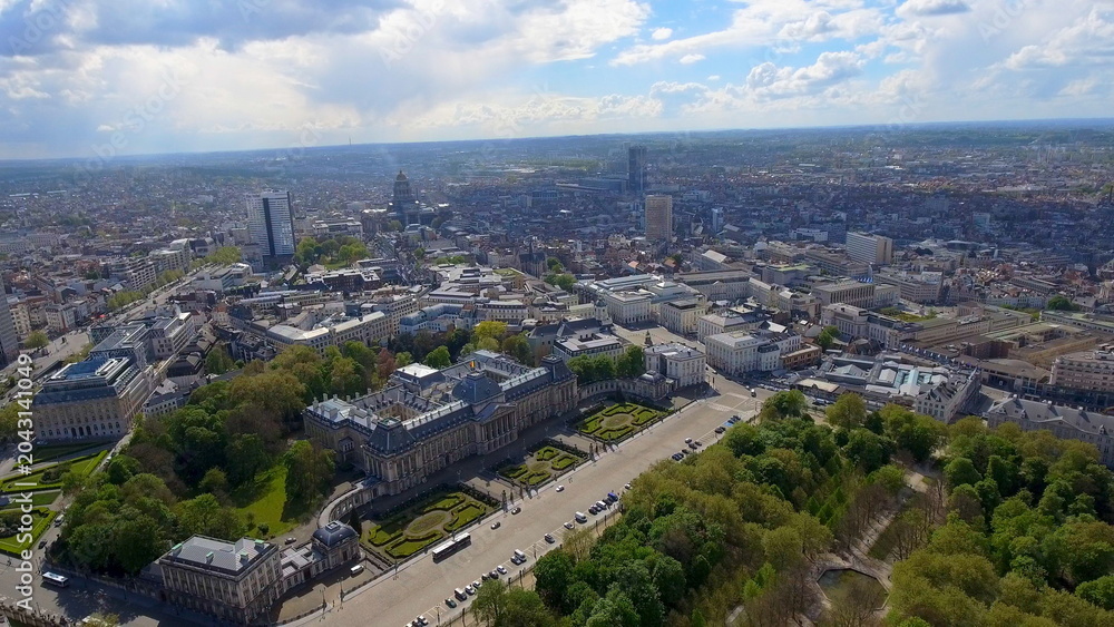 Fototapeta premium 4K aerial drone view of Brussels, Belgium. Panoramic cityscape featuring the historic Royal Palace of Brussels, Brussels Park, and distant skyline.