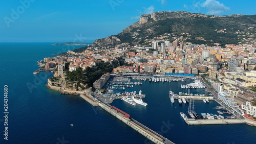 4K aerial drone view of Port Hercule in Monaco. Beautiful luxury marina cityscape featuring superyachts, Monaco-Ville, and the Mediterranean Sea.