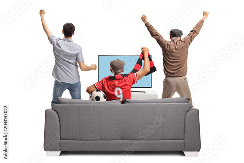 Rear view shot of a group of excited men watching football on tv and cheering