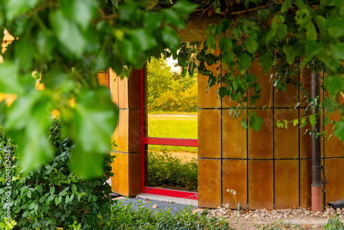 Nature frames a vibrant doorway to serenity in a peaceful garden setting on a sunny afternoon
