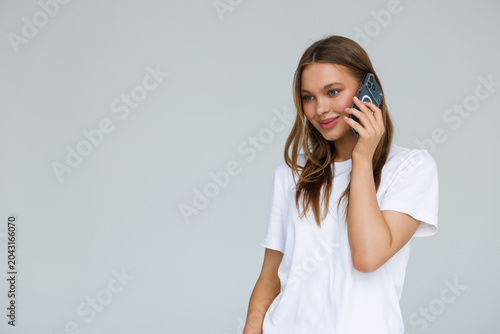 Принти на полотні young smiling woman talking on the phone on white background