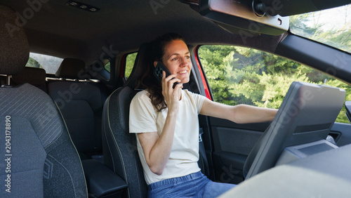 Schilderij op canvas Woman driving car talking on cell phone