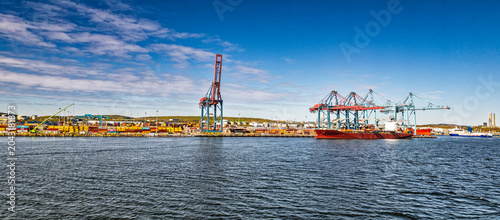 Cargo Ship and Container Cranes at Busy Industrial Port Under Blue Sky and Calm Water, Gothenburg, Sweden