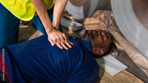 Factory Worker Emergency Rescue Training Inside Industrial Manufacturing Facility During Workplace Safety And First Aid Procedure Session
