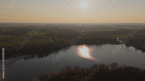 Aerial approach over Engelenmeer lake toward Vlijmen at Golden Hour