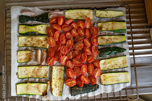 Baked cherry tomatoes Zucchini and onion on a baking rack