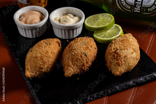Bild auf Leinwand Fried Brazilian Bolinho Croquettes on Slate Platter with Dipping Sauces and Lime