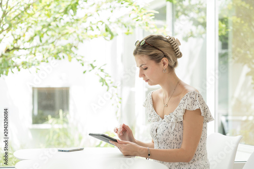 Young woman sitting and using digital tablet in the office
