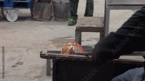 Artisan Shaping Molten Glass in a Warm Workshop