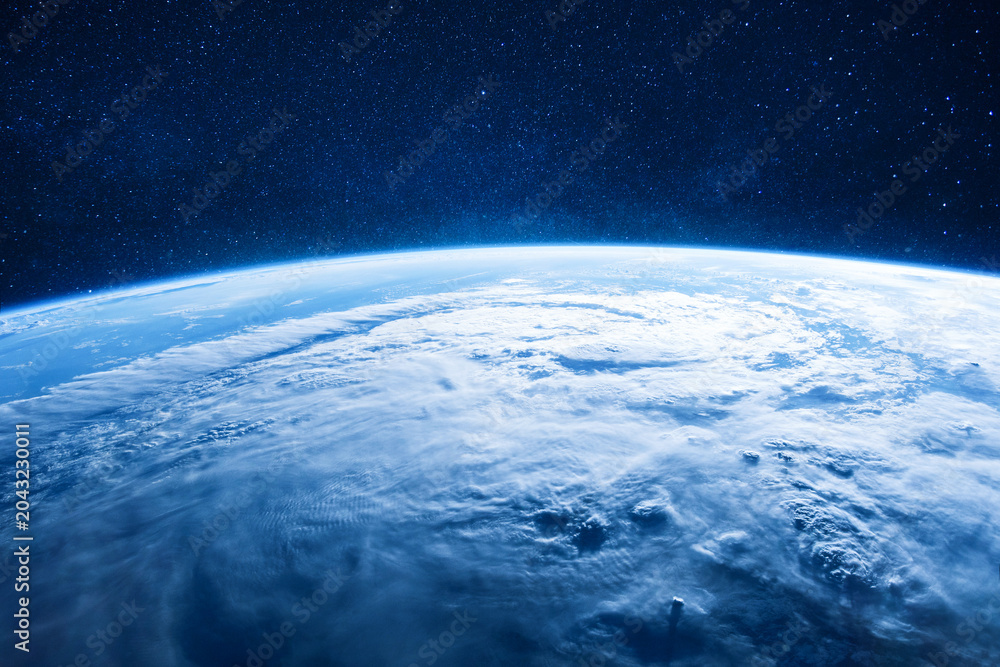 Naklejka premium Breathtaking view of planet Earth from space, featuring a massive hurricane system, white clouds, and blue oceans under a clear, starry atmosphere