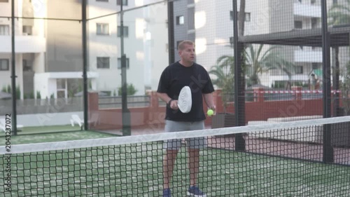 Man playing padl on outdoor court, Focus on the net