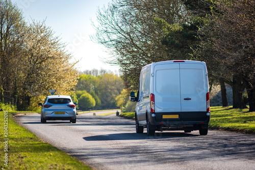Van Driving on Curving Suburban Road Through Green Landscape on Sunny Afternoon in England UK