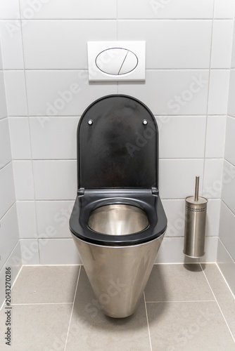 Toilet in a gray tiled public restroom