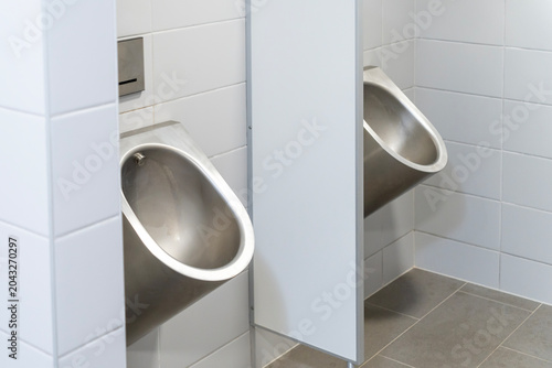 Urinals in a gray tiled public toilet