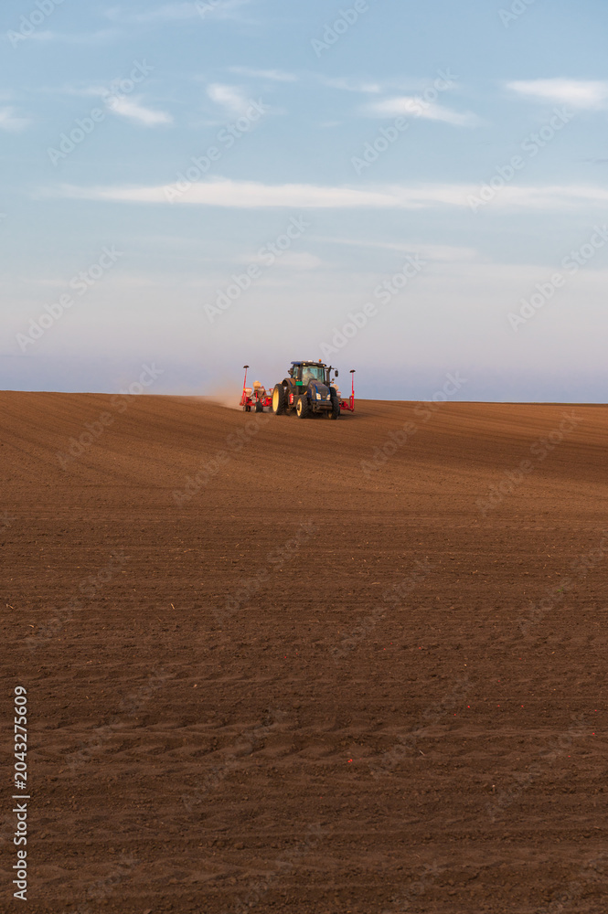Fototapeta premium Tractor working on agricultural field in spring