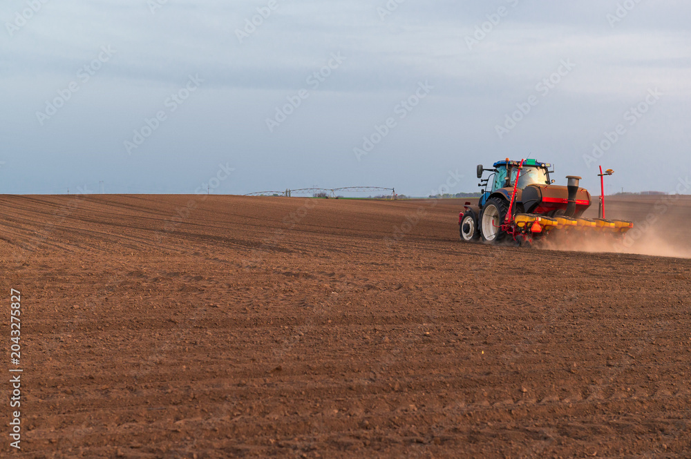 Fototapeta premium Tractor working on agricultural field in spring