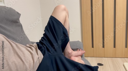 ソファーで寝転んでイライラする男性