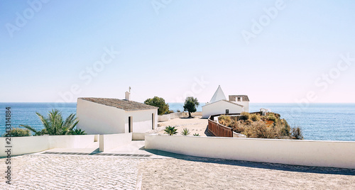 Photography White chapel, on rocky headland overlooking the Atlantic, Algarve