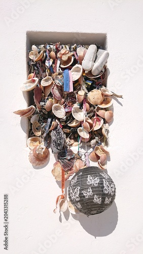 Votive offerings of seashells and mementos on chapel wall, Algarve
