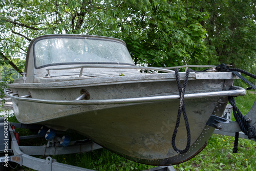 Vintage aluminum motorboat  on a trailer outdoors