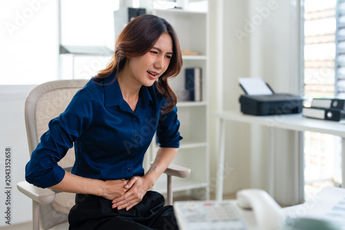 Bild auf Leinwand Young asian woman business worker suffering for stomach ache at office