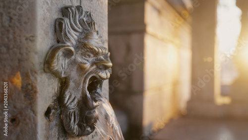 Photos Venetian wall fountain with grotesque mascaron water spout at sunrise