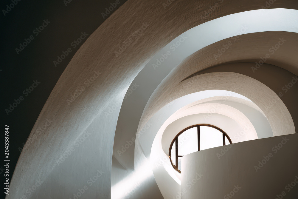 Fototapeta premium Abstract architectural interior with curving white walls and circular window.
