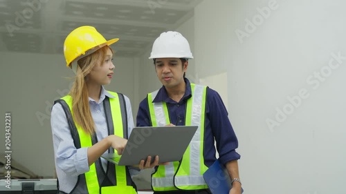 Construction worker safety vest hard hat laptop walkie talkie inspection teamwork indoor site engineer planning office collaboration construction worker meeting indoor site with laptop safety vest
