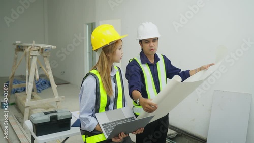 Construction site interior engineer team hard hat safety vest blueprint renovation work planning meeting construction worker inspection laptop site teamwork interior engineer blueprint safety helmet