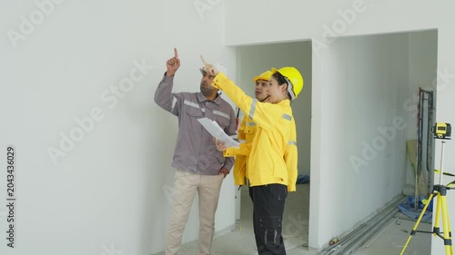 Construction site inspector worker plan wall helmet safety interior renovation building planning blueprint teamwork indoor room project survey hotes and work execution detailed scene documentation