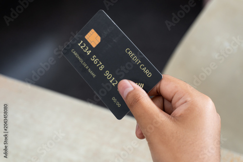 Hand holding a credit card on a light background with copy space. Concept of online payment, digital banking, shopping, finance, and cashless transactions.