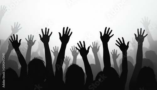 Silhouette of a large crowd of people with raised hands at a concert or protest event