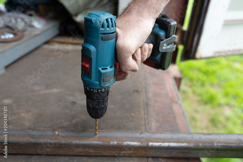 Tableau sur toile A close-up of a hand holding a cordless drill