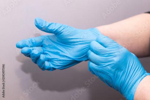 Foto Close-up of hands putting on blue nitrile protective gloves