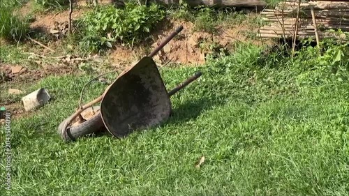 Abandoned Wheelbarrow Resting on Lawn in Countryside Garden