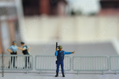 Miniature people toy figure photography. A military force standing in front of barricades, doing road diversion