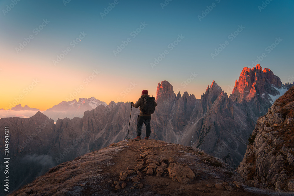 Obraz premium Hiker Admiring on Mountain Peak at Sunrise Overlooking Cadini di Misurina Dolomites Italy