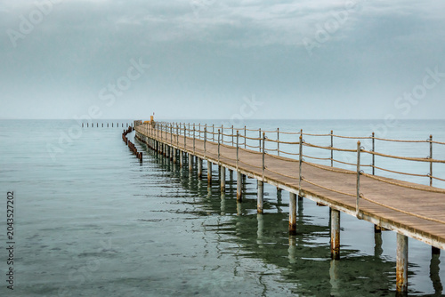 Wooden pier in the sea in dusk. Beautiful seascape