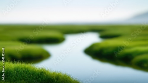 A serene, soft-focus landscape depicts a winding water channel through lush green fields