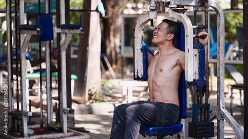 Foto Man training chest muscles at outdoor gym with intense effort and determination