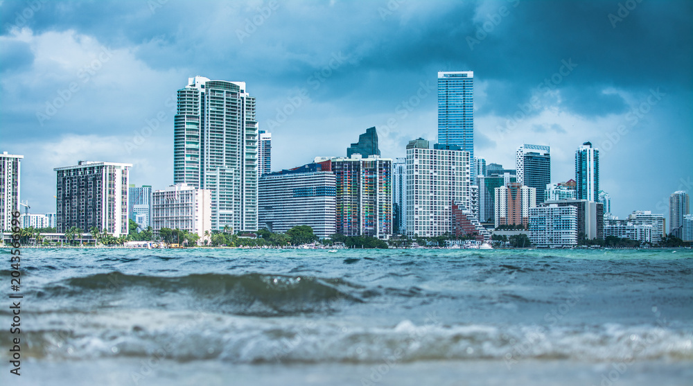 Naklejka premium Miami Skyline Viewed From Key Biscayne Beach Across Ocean Waves On Bright Sunny Summer Day