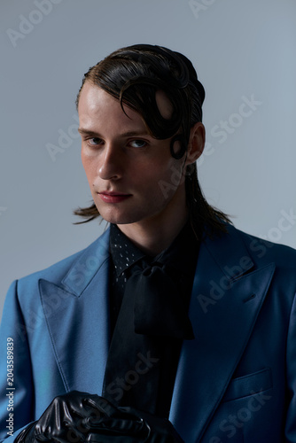 Stylish young man poses confidently in a modern studio setting
