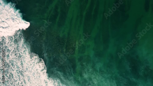 Aerial drone view of surfers, surfing paddling, duck diving, with beautiful blue collars and glass sea