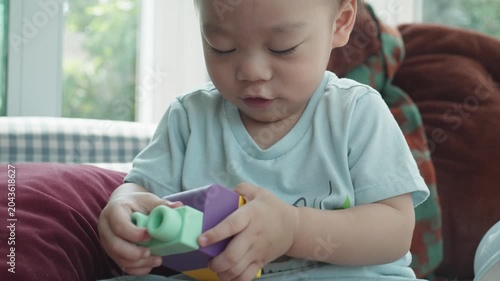 A young child focuses intently while playing with colorful building blocks. This joyful moment captures the essence of early childhood creativity and learning through play, promoting development and i