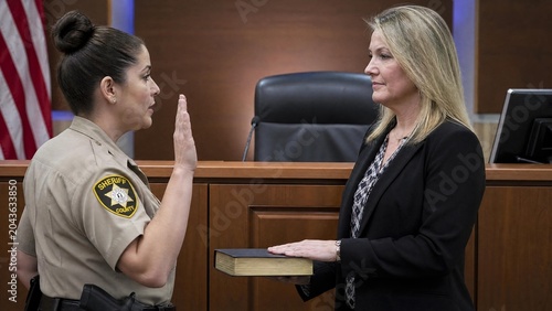 Female Sheriff Deputy Taking Formal Oath of Office in Courtroom on Bible
