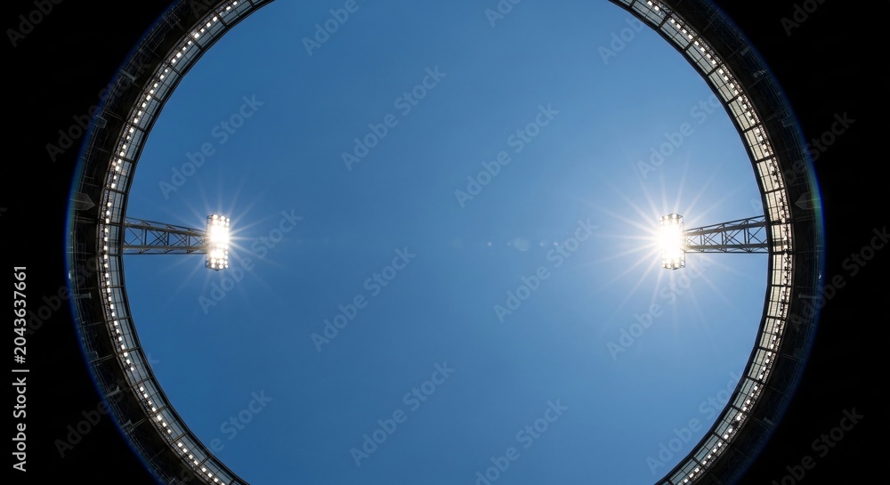 Naklejka premium Football stadium installation with rose gold details under bright lights at night.