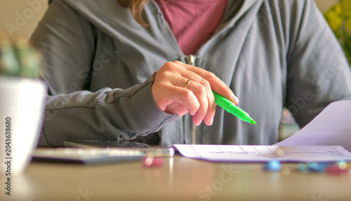 Woman working on financial documents with a green highlighter
