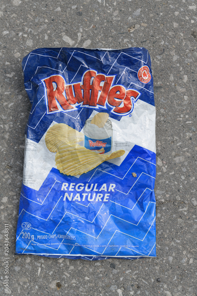 Naklejka premium discarded bag of Ruffles regular potato chip on asphalt pavement, Toronto