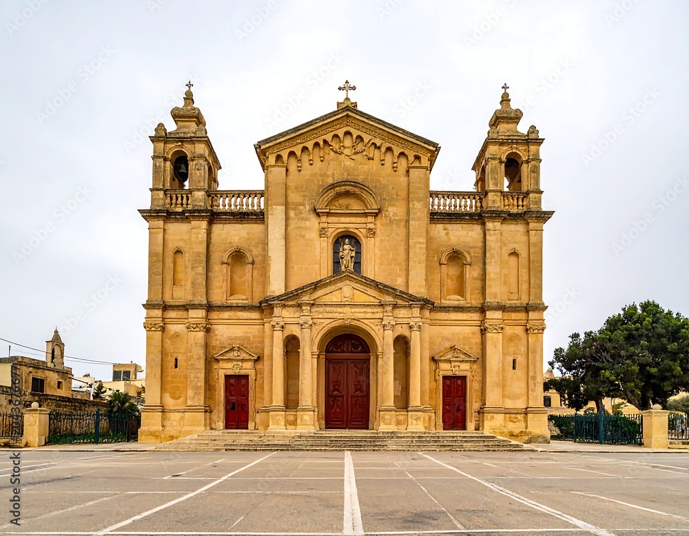 Obraz premium A large, ornate church with a central arched doorway and two bell towers